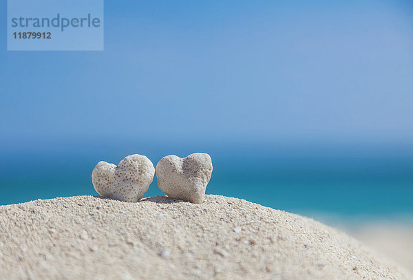 Zwei weiße herzförmige Korallenfelsen  die zusammen auf Sand am Strand liegen; Honolulu  Oahu  Hawaii  Vereinigte Staaten von Amerika