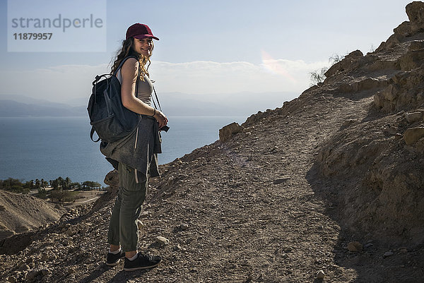 Eine junge Frau posiert beim Wandern in Ein Gedi  mit dem Toten Meer im Hintergrund  Bezirk Totes Meer; Südbezirk  Israel'.