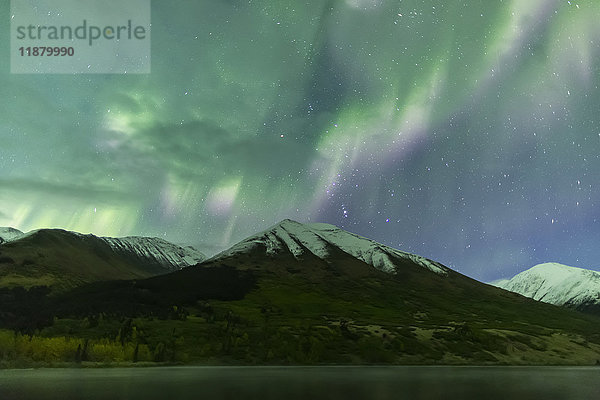 Leuchtend grünes Polarlicht tanzt über den Kenai-Bergen  der Summit Lake spiegelt den Himmel im Vordergrund  Moose Pass  Kenai-Halbinsel  Süd-Zentral-Alaska; Alaska  Vereinigte Staaten von Amerika'.