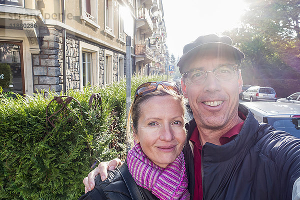 Ein Paar nimmt ein Selbstporträt neben einer Straße und einem Gebäude auf; Lausanne  Schweiz'.