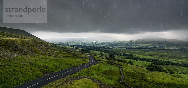 Regen  der von einem stürmischen Himmel über eine üppige  grüne Landschaft fällt; North Yorkshire  England'.