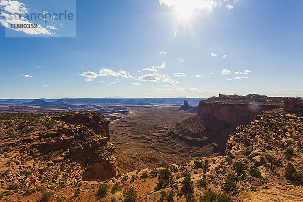 Trockene Landschaft mit Felsen und zerklüftetem Gelände unter einem blauen Himmel mit Wolken und Sonnenlicht; Utah  Vereinigte Staaten von Amerika'.