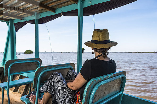 Eine Frau sitzt in einem Boot und schaut auf das Wasser  während es einen Fluss hinunterfährt; Provinz Siem Reap  Kambodscha