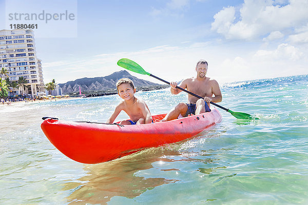 Vater und Sohn beim gemeinsamen Kajakfahren vor dem Strand von Waikiki; Honolulu  Oahu  Hawaii  Vereinigte Staaten von Amerika'.