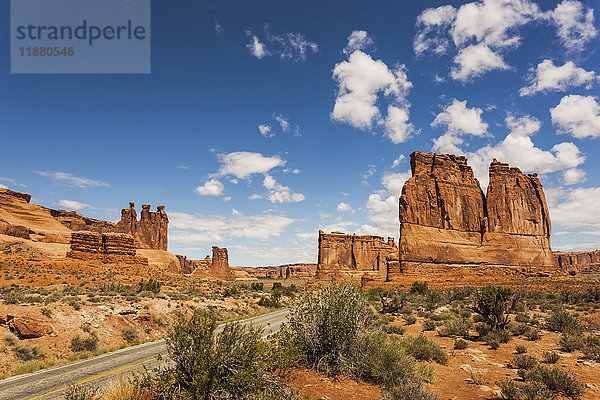 Zerklüftete Felsformationen und Sträucher in der Wüste  durch die eine Straße führt; Arizona  Vereinigte Staaten von Amerika'.
