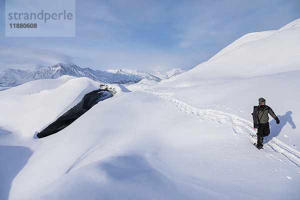 Ein Schneeschuhläufer überquert den schneebedeckten Canwell-Gletscher im Winter; Alaska  Vereinigte Staaten von Amerika'.