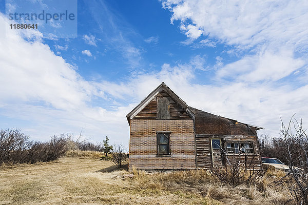 Ein altes  verlassenes Holzhaus und ein Oldtimer in der Prärie; Alberta  Kanada'.