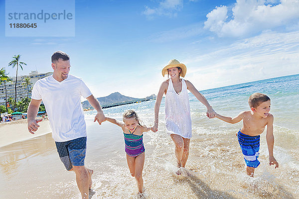 Vierköpfige Familie im Sommerurlaub in Waikiki Beach; Honolulu  Oahu  Hawaii  Vereinigte Staaten von Amerika'.