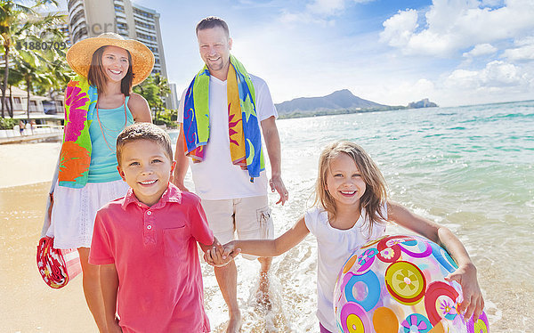 Vierköpfige Familie im Sommerurlaub in Waikiki Beach; Waikiki  Oahu  Hawaii  Vereinigte Staaten von Amerika'.