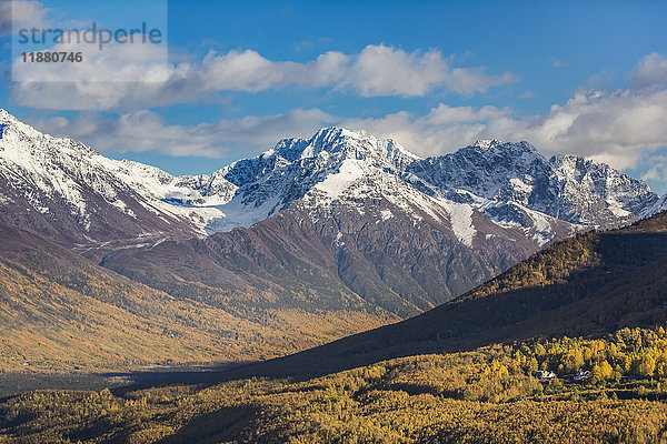 Eagle River Valley  Häuser zwischen den Bäumen im Vordergrund  herbstlich gefärbte Bäume füllen das Tal  Schnee bedeckt die Chugach Mountains im Hintergrund  Eagle River  South-central Alaska; Alaska  Vereinigte Staaten von Amerika'.