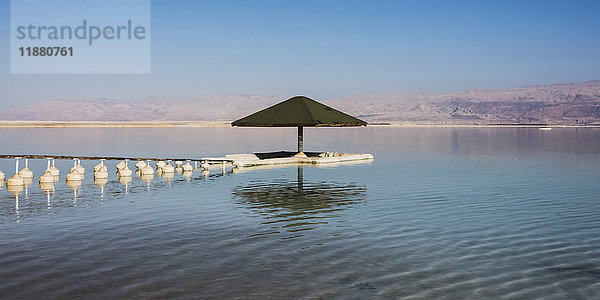 Ein Regenschirm  Bojen und eine Anlegestelle im Toten Meer; Südbezirk  Israel'.