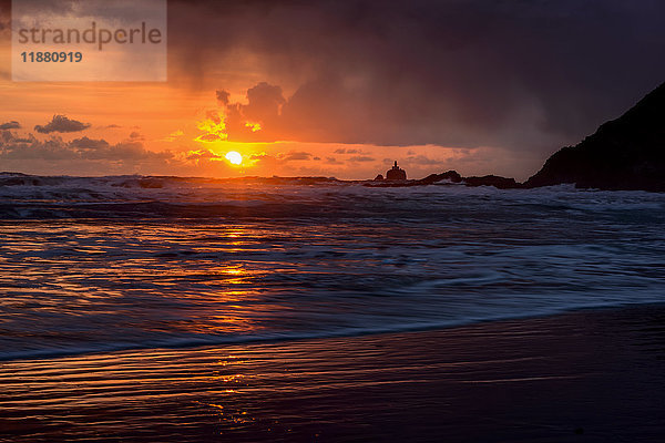 Regen fällt auf die Wellen während eines Sonnenuntergangs an der Küste von Oregon; Cannon Beach  Oregon  Vereinigte Staaten von Amerika'.