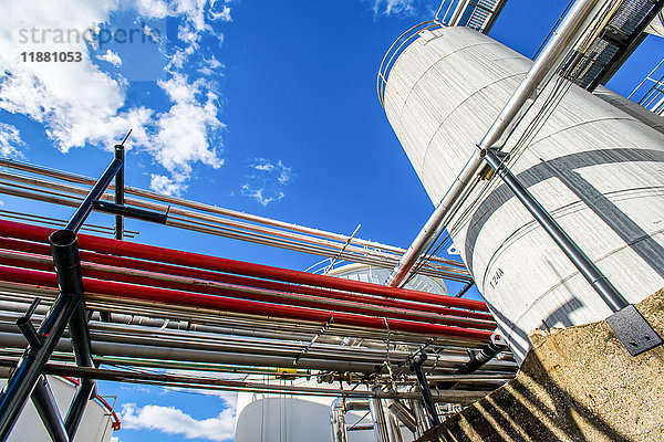 Niedrigwinkelansicht von industriellen Rohrleitungen und Lagertanks in einer Biokraftstoffanlage