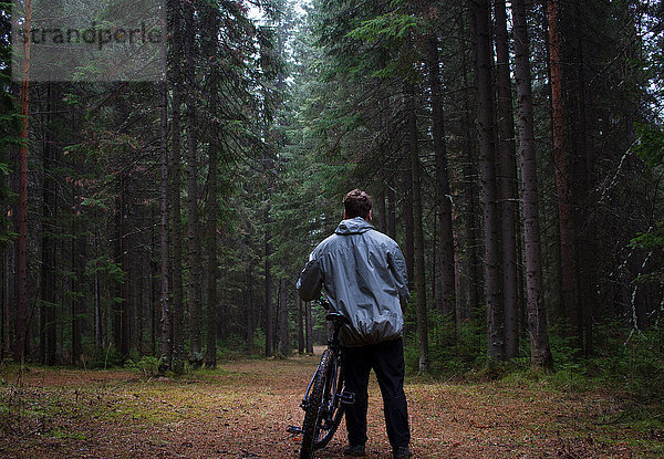 Rückansicht eines männlichen Mountainbikers mit Blick auf den Wald