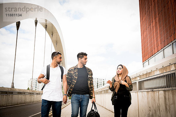 Drei Freunde  die über die Stadtbrücke gehen