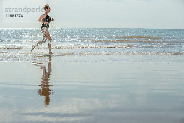 Frau läuft am Strand  Folkestone  UK