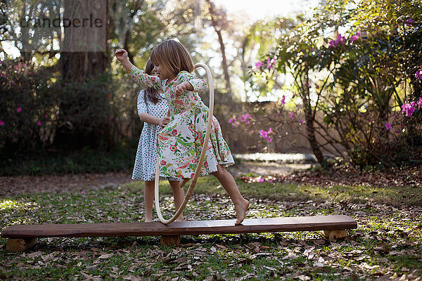 Mädchen rennt durch einen Plastikreifen im Garten