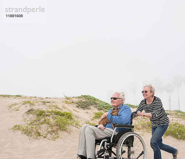 Ältere Frau schiebt Ehemann im Rollstuhl auf Dünen  Playa del Ray  Kalifornien  USA