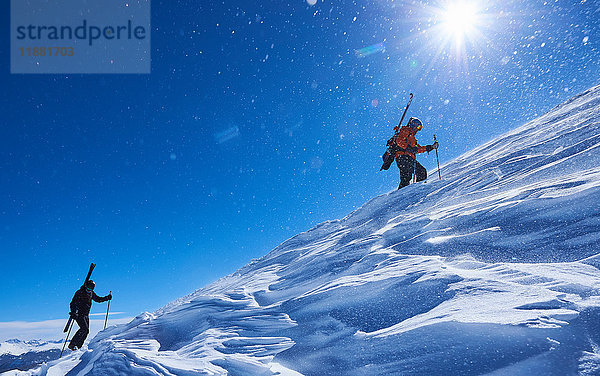 Zwei männliche Skifahrer stapfen den schneebedeckten Berg hinauf  Aspen  Colorado  USA