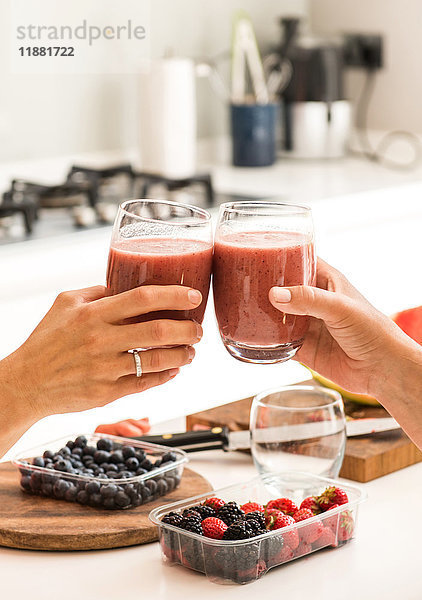 Freunde stoßen mit Smoothies an