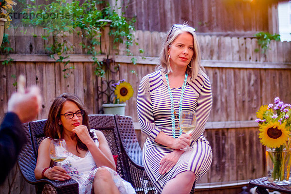 Zwei Frauen bei Gartenparty  sitzend  im Gespräch
