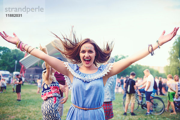 Junge Boho-Frau tanzt und springt vor Freude am Festival