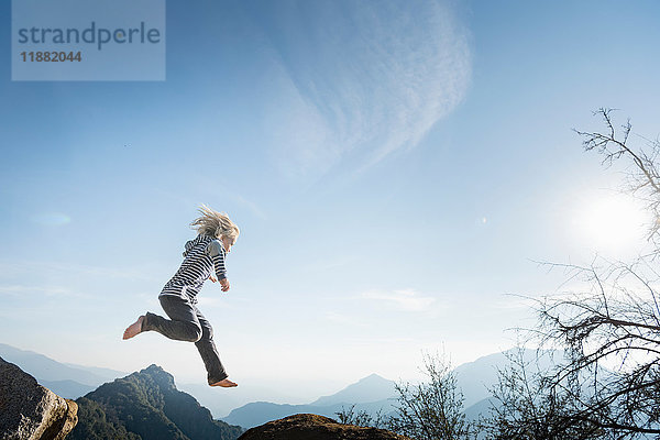 Junge springt  blauer Himmel im Hintergrund  Sequoia-Nationalpark  Kalifornien  USA