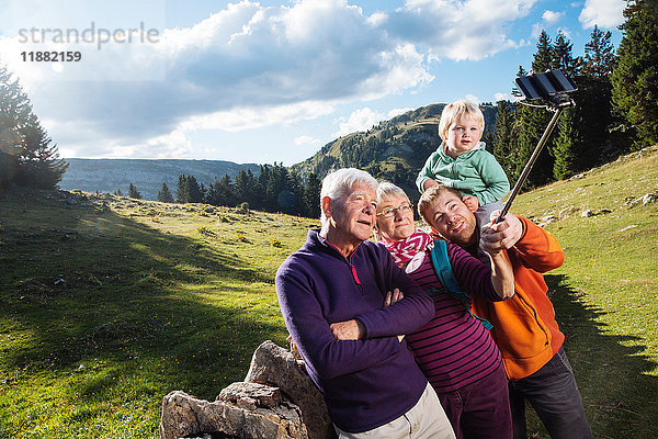Drei-Generationen-Familie in ländlicher Umgebung  Selfie  mit Smartphone und Selfie-Stick  Genf  Schweiz  Europa