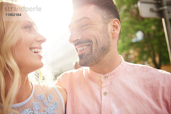 Porträt eines Paares im Sonnenlicht von Angesicht zu Angesicht lächelnd
