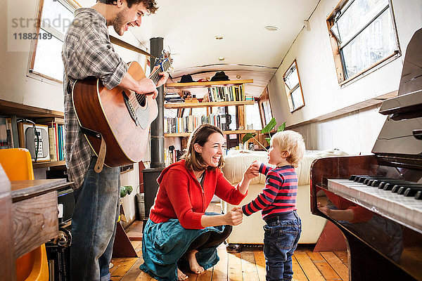 Familie mit einem kleinen Jungen  der auf einem Lastkahn lebt  Gitarre spielt und tanzt