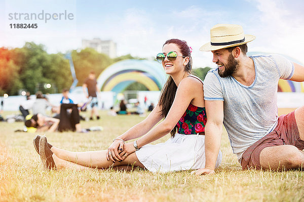 Ehepaar sitzt beim Festival gemeinsam auf dem Rasen