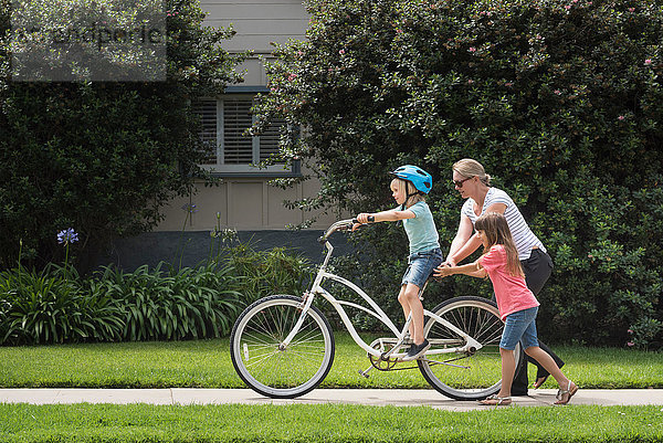 Junge auf der Straße lernt Fahrrad fahren