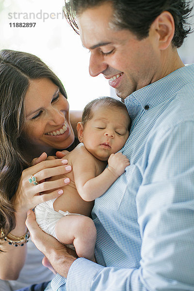 Porträt von Mutter und Vater  ein Neugeborenes haltend  lächelnd