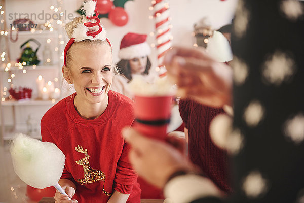 Junge Frau und Mann mit Zuckerwatte und Popcorn auf Weihnachtsfeier