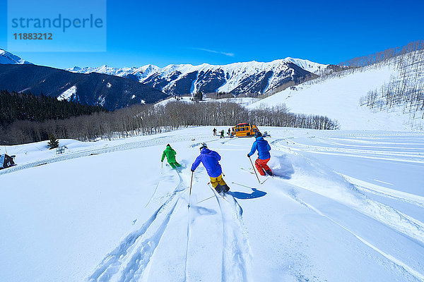 Rückansicht der Männer beim Abfahren einer schneebedeckten Skipiste  Aspen  Colorado  USA