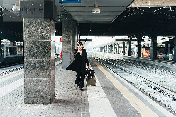 Geschäftsfrau benutzt Mobiltelefon im Bahnhof  Mailand  Italien