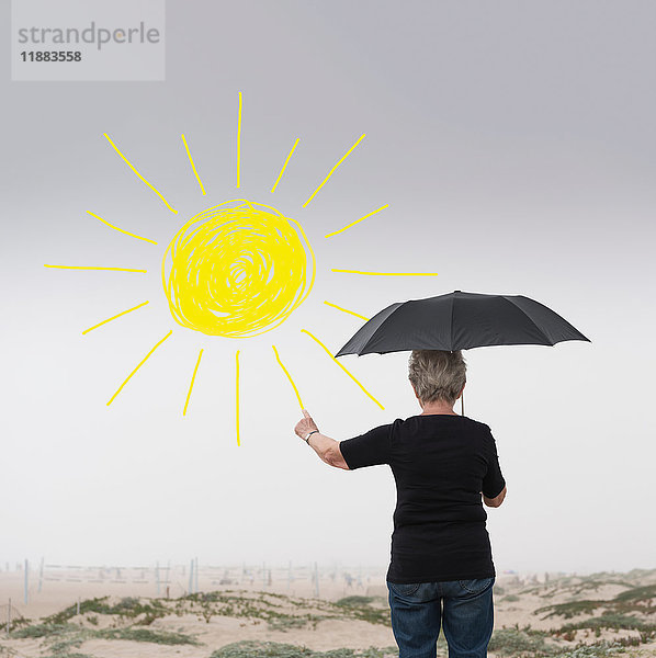 Ältere Frau mit Regenschirm zieht Sonne in die Luft