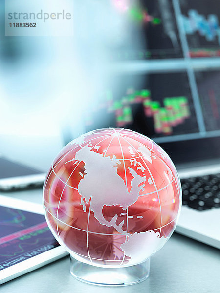 Globus mit digitalem Tablett und Laptop zur Darstellung des internationalen Geschäftsverkehrs