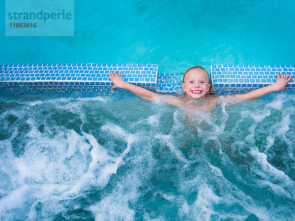 Porträt eines süßen Jungen  der im Freibad planscht