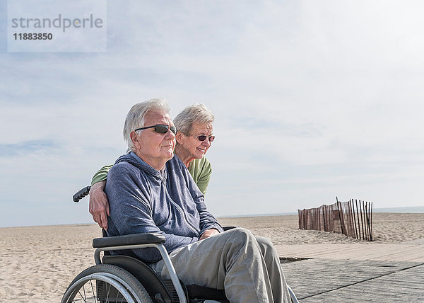 Älterer Mann im Rollstuhl mit Frau am Strand  Santa Monica  Kalifornien  USA