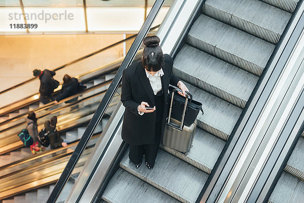 Geschäftsfrau benutzt Mobiltelefon auf Rolltreppe  Mailand  Italien