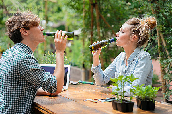 Paar trinkt Bier im Garten