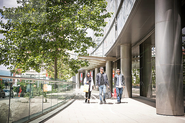 Drei Freunde gehen gemeinsam die Straße entlang