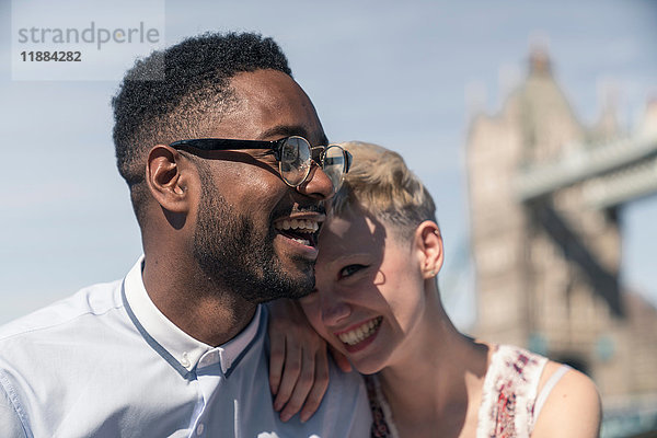 Junges Paar lacht gemeinsam im Freien  Tower Bridge im Hintergrund  London  England  UK