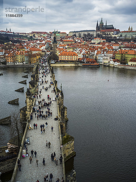 Fußgänger auf der Karlsbrücke über die Moldau und die Prager Burg in der Ferne; Prag  Tschechische Republik'.