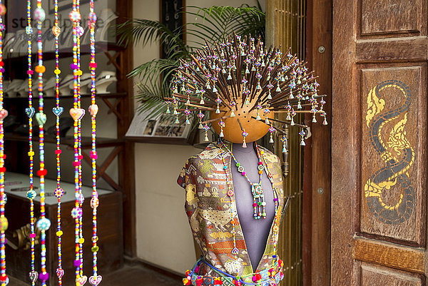 Eine Schaufensterpuppe mit traditioneller asiatischer Kleidung  Perlenschmuck und zahlreichen Stöcken mit Perlen  die aus dem Kopf herausragen; Luang Prabang  Provinz Luang Prabang  Laos