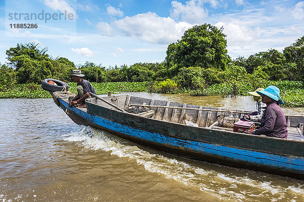 Ein Paar fährt in einem langen Holzboot den Fluss hinunter; Kampong Phluk  Provinz Siem Reap  Kambodscha'.