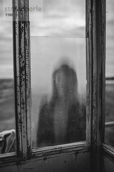 Defokussiertes Bild des Mädchens durch das Fenster des alten Aussichtsturms gesehen