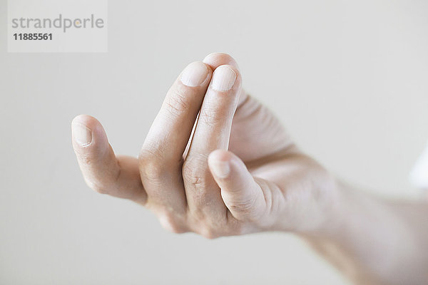 Abgeschnittenes Bild der Handbewegung vor weißem Hintergrund