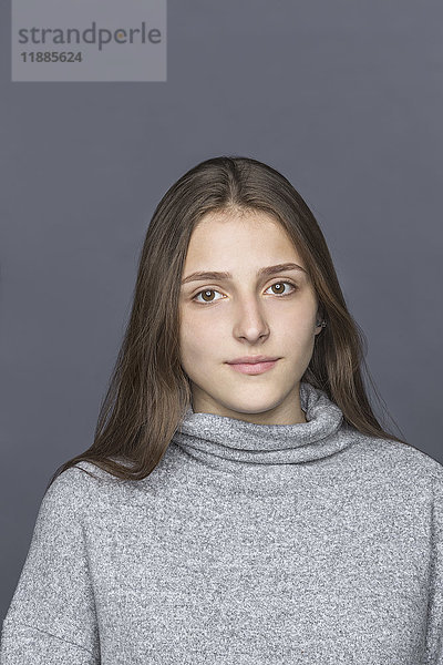 Porträt eines Teenagermädchens vor grauem Hintergrund
